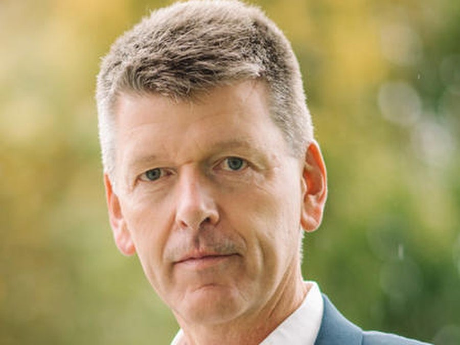 Nestle CFO François-Xavier Roger headshot with blurry green background