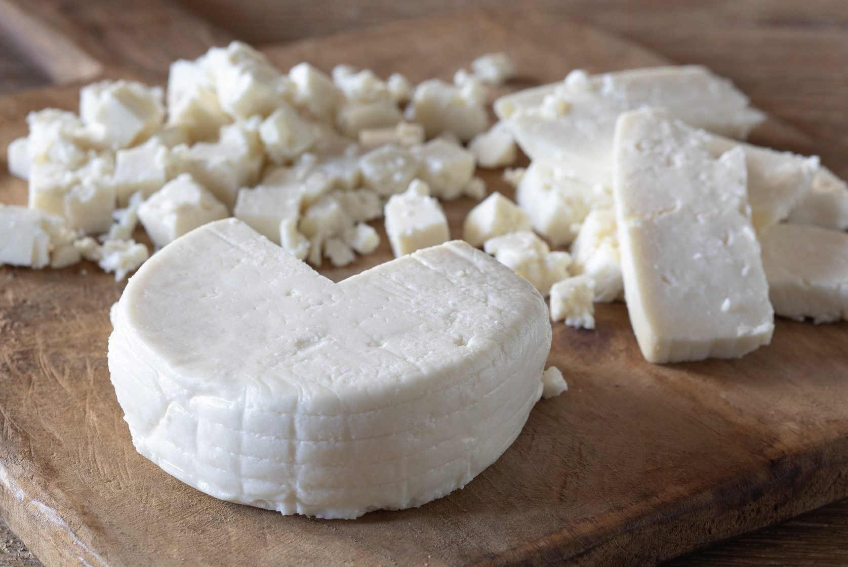 Man is a cheese maker in the process of producing different varieties of  cheese in the industry. Milk cheese making Stock Photo